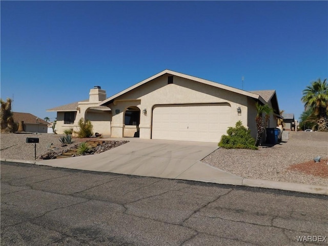 view of front of property featuring an attached garage, a chimney, concrete driveway, and stucco siding