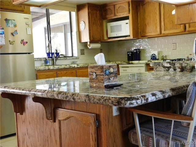 kitchen with white appliances and brown cabinetry