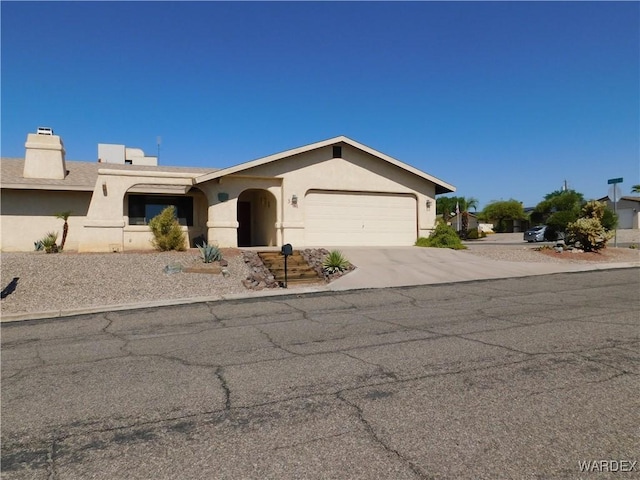 view of front of property with driveway, a garage, and stucco siding