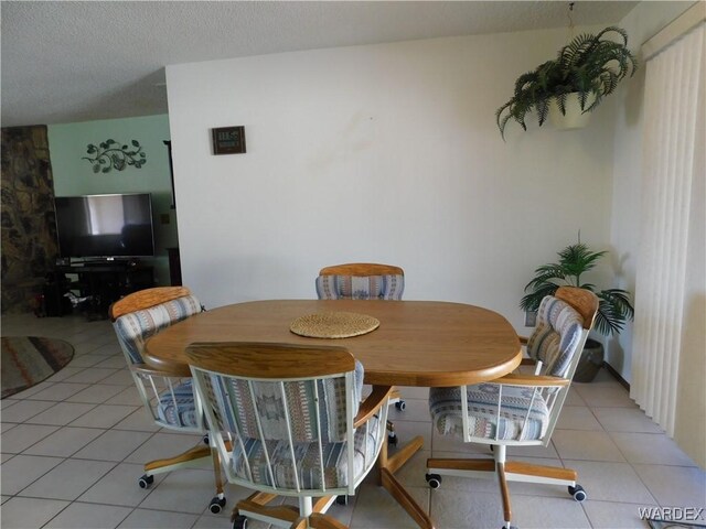 dining area featuring light tile patterned floors and a textured ceiling