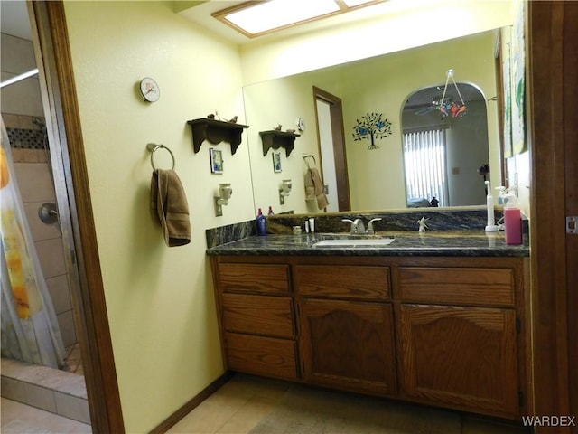 full bathroom featuring tile patterned flooring, a ceiling fan, vanity, baseboards, and a shower stall