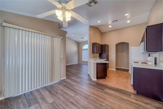 kitchen featuring range, visible vents, light countertops, and arched walkways