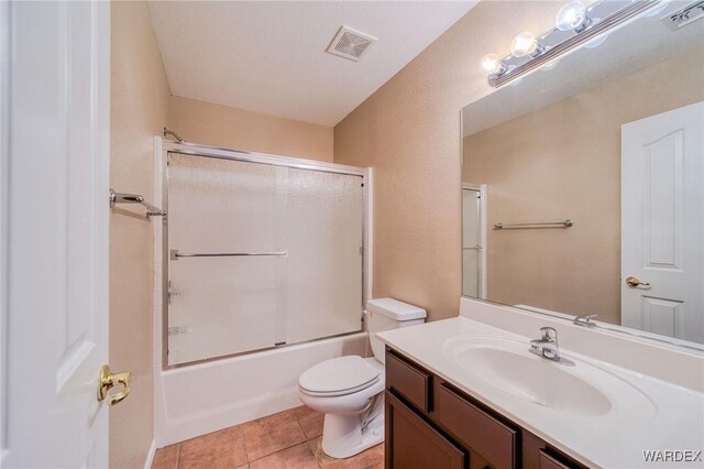 full bathroom featuring tile patterned flooring, visible vents, toilet, and combined bath / shower with glass door