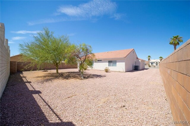 view of yard with a fenced backyard and central AC