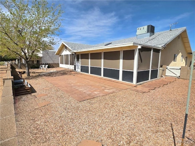 exterior space with a patio, a gate, a sunroom, central AC, and fence