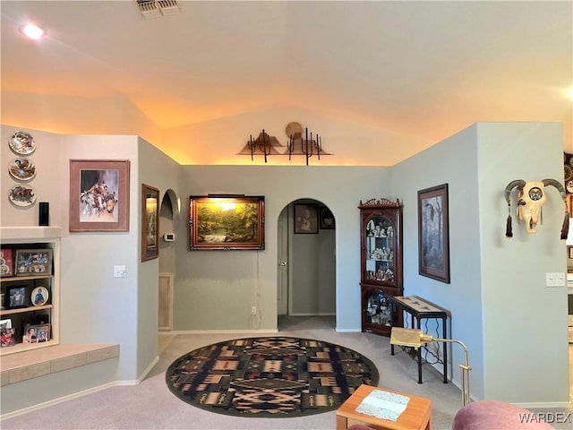 carpeted foyer with arched walkways, baseboards, vaulted ceiling, and visible vents