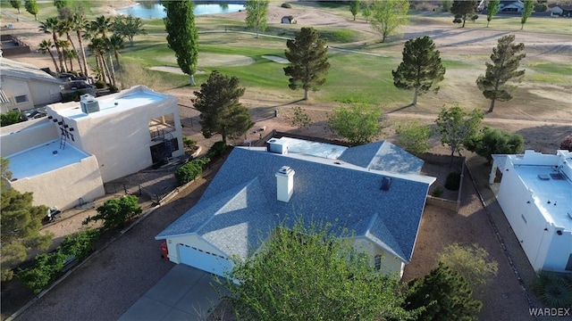 drone / aerial view featuring golf course view and a water view