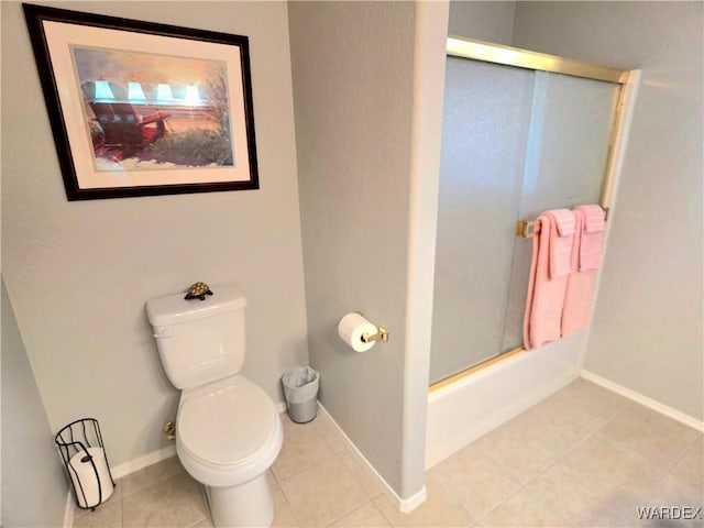 full bathroom featuring tile patterned floors, toilet, enclosed tub / shower combo, and baseboards