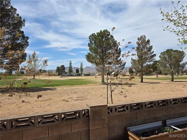 view of yard with golf course view and a mountain view