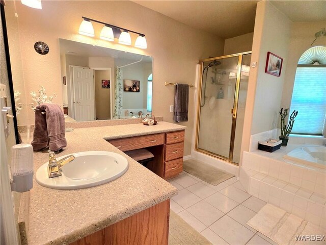 full bath featuring a bath, tile patterned flooring, a stall shower, and vanity