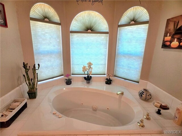 full bath featuring a whirlpool tub and plenty of natural light