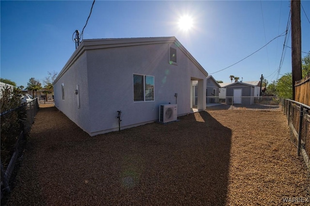 rear view of house with ac unit, a fenced backyard, and stucco siding