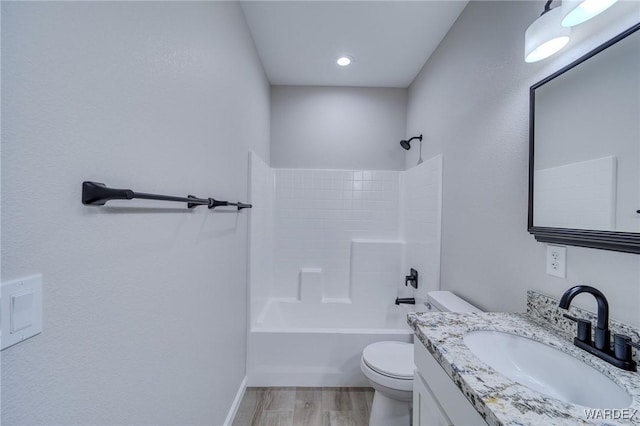 full bath featuring toilet, vanity, wood finished floors, and bathing tub / shower combination