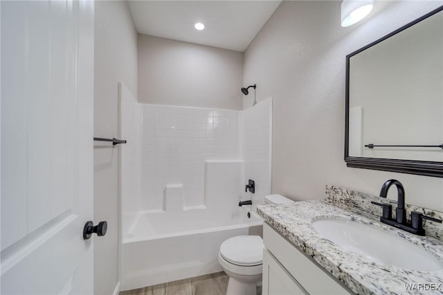 bathroom featuring  shower combination, toilet, wood finished floors, and vanity