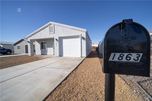 view of front of house featuring a garage, driveway, and stucco siding