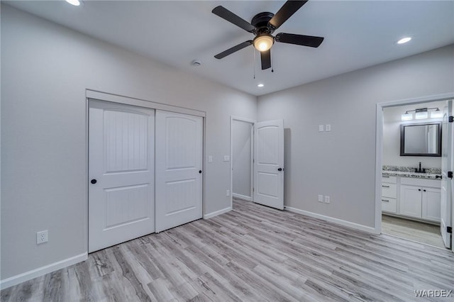 unfurnished bedroom with baseboards, ensuite bath, light wood-style flooring, a closet, and recessed lighting