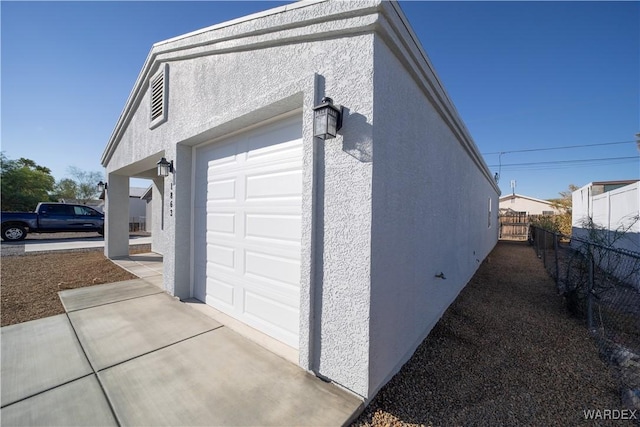 garage with fence and driveway