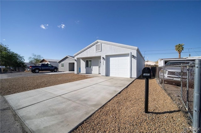 ranch-style home featuring concrete driveway, an attached garage, fence, and stucco siding