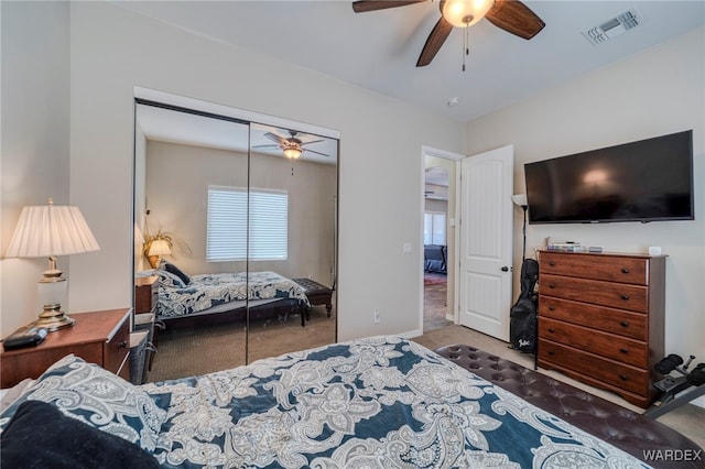 carpeted bedroom featuring a ceiling fan, a closet, visible vents, and baseboards