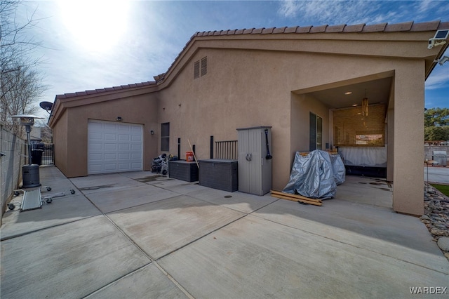 view of side of home with driveway, an attached garage, and stucco siding