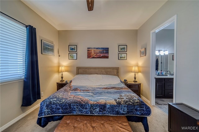 bedroom featuring light carpet, ensuite bathroom, and baseboards