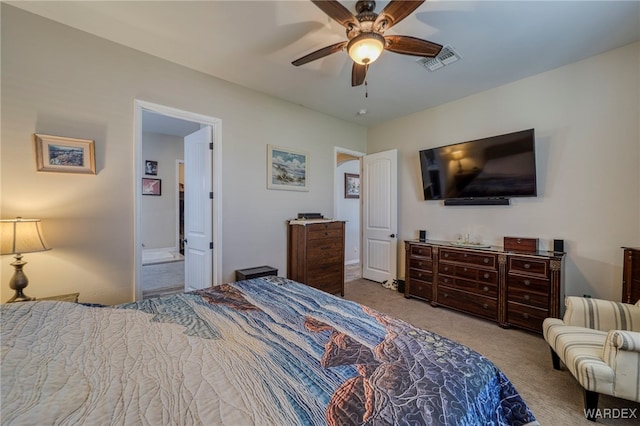 bedroom with a ceiling fan, visible vents, light carpet, and ensuite bath