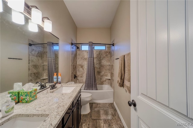 full bath with shower / bath combination with curtain, double vanity, a sink, and toilet