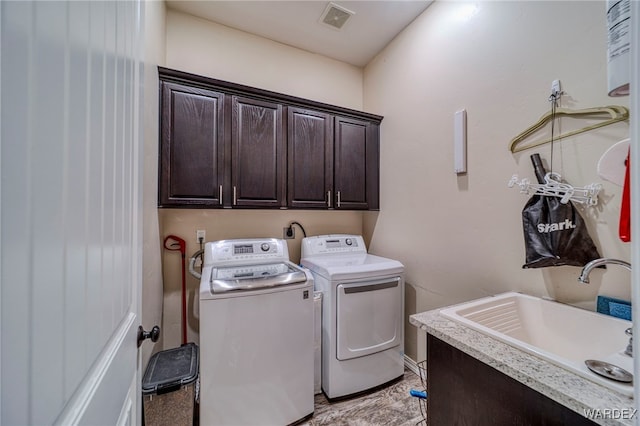 washroom featuring visible vents, separate washer and dryer, a sink, and cabinet space