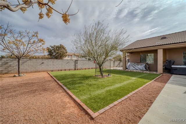 view of yard with a hot tub, a patio area, and a fenced backyard