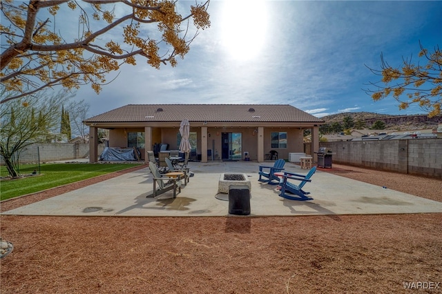 back of house with a patio area, a fenced backyard, a tile roof, and stucco siding