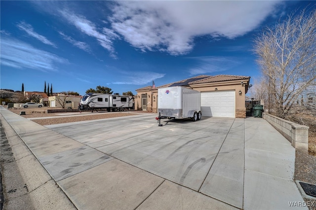 exterior space featuring driveway, a tile roof, a residential view, and stucco siding