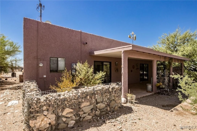 back of house featuring stucco siding and a patio area