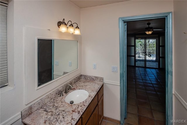 bathroom with vanity, tile patterned flooring, baseboards, and ornamental molding