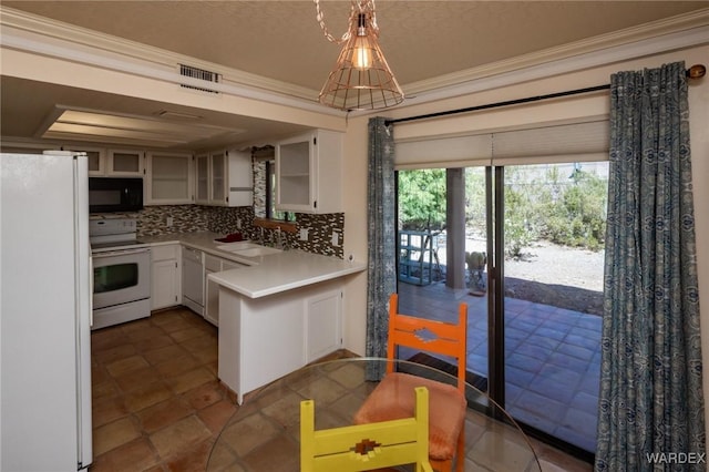 kitchen with a sink, decorative backsplash, white appliances, crown molding, and light countertops