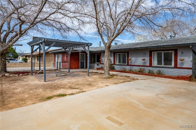 ranch-style house with brick siding and a pergola