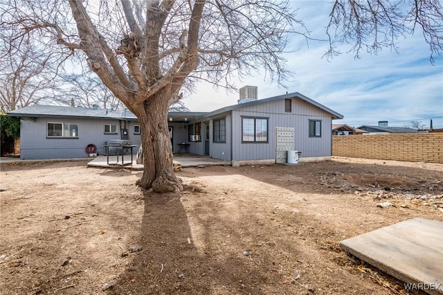 rear view of property featuring a patio and fence