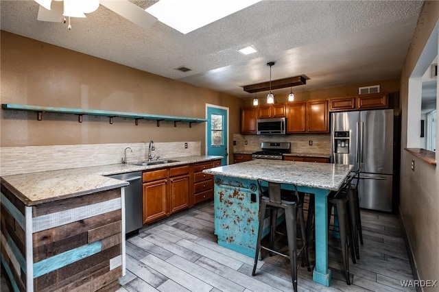 kitchen featuring open shelves, brown cabinets, stainless steel appliances, and a sink