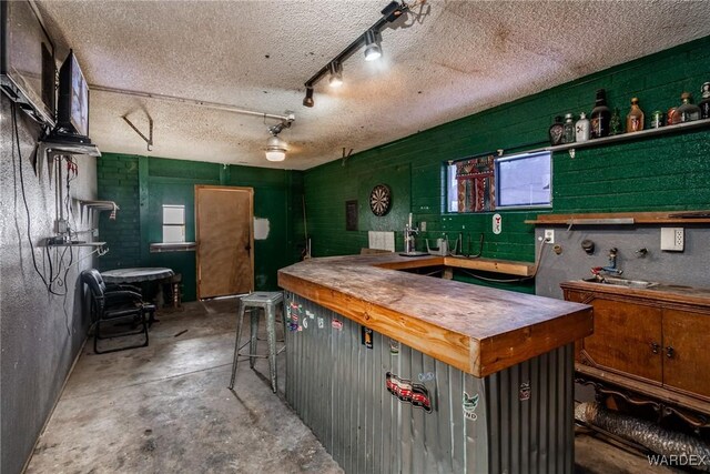 kitchen with unfinished concrete floors and a textured ceiling