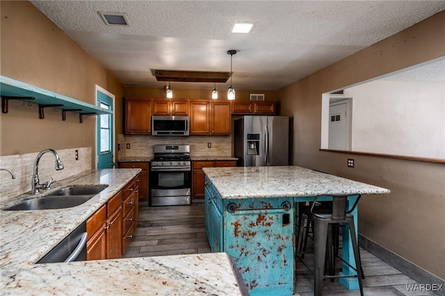 kitchen with stainless steel appliances, a sink, brown cabinets, decorative backsplash, and open shelves