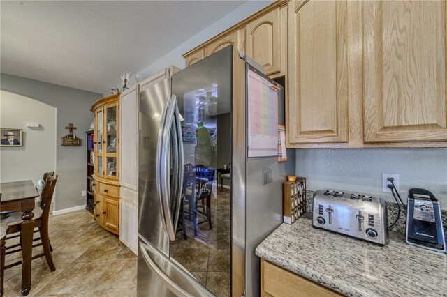 1919 Richardo Ave, Bullhead City, AZ 86442 - kitchen with smart refrigerator, light brown cabinets, baseboards, and light stone counters
