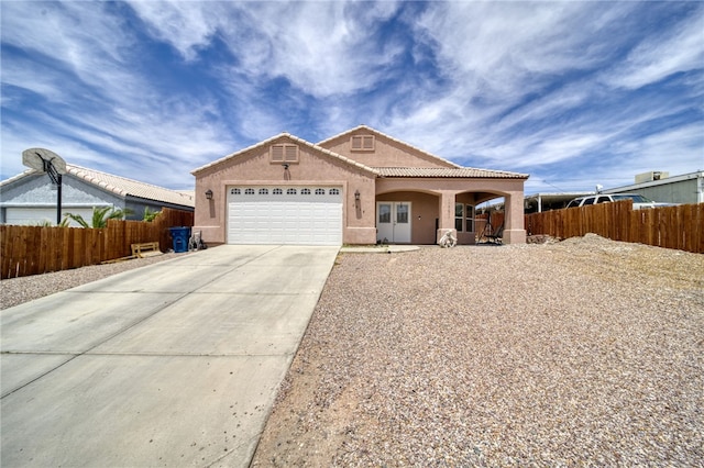 1919 Richardo Ave, Bullhead City, AZ 86442 - view of front facade with stucco siding, driveway, an attached garage, fence, and a tiled roof