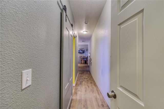 1919 Richardo Ave, Bullhead City, AZ 86442 - corridor with a textured ceiling, light wood-style floors, and a barn door