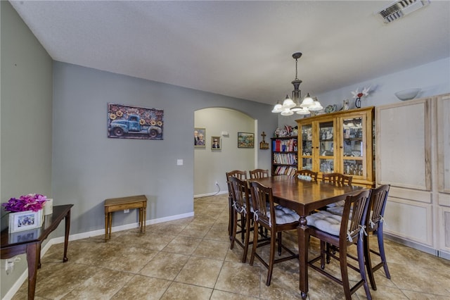 1919 Richardo Ave, Bullhead City, AZ 86442 - dining space featuring arched walkways, a chandelier, light tile patterned floors, and baseboards