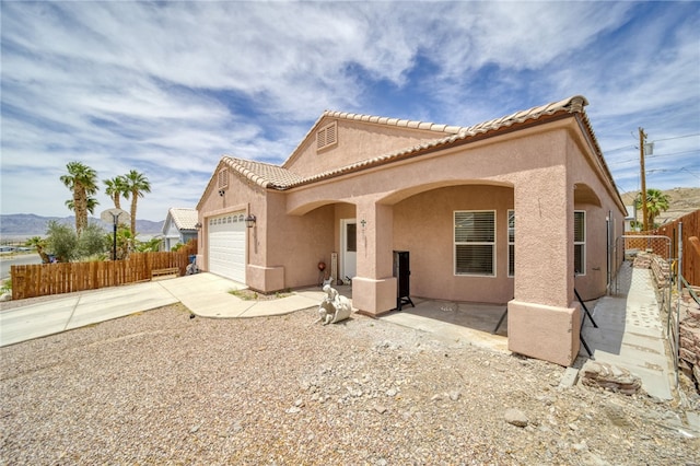 1919 Richardo Ave, Bullhead City, AZ 86442 - mediterranean / spanish-style home featuring an attached garage, stucco siding, fence, and driveway