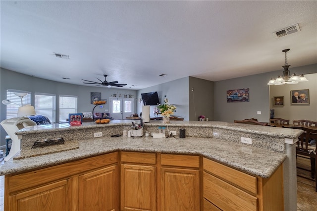 1919 Richardo Ave, Bullhead City, AZ 86442 - kitchen featuring open floor plan, a chandelier, ceiling fan, hanging light fixtures, and light stone countertops