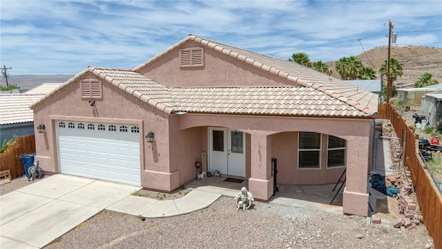 1919 Richardo Ave, Bullhead City, AZ 86442 - view of front of home with stucco siding, an attached garage, fence, concrete driveway, and a tiled roof