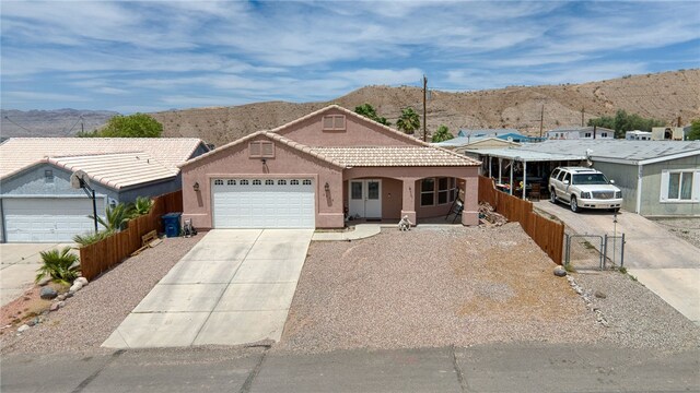 1919 Richardo Ave, Bullhead City, AZ 86442 - view of front of house with concrete driveway, a mountain view, fence, a garage, and stucco siding