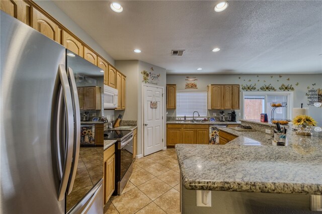 1919 Richardo Ave, Bullhead City, AZ 86442 - kitchen with appliances with stainless steel finishes, a sink, recessed lighting, light tile patterned flooring, and light stone countertops