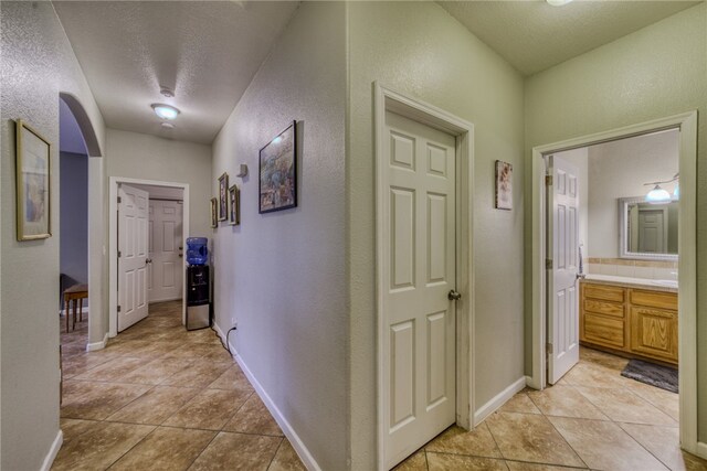 1919 Richardo Ave, Bullhead City, AZ 86442 - hallway featuring a textured wall, light tile patterned flooring, baseboards, and a textured ceiling