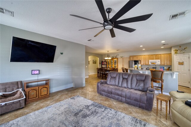 1919 Richardo Ave, Bullhead City, AZ 86442 - living area featuring arched walkways, ceiling fan, light tile patterned flooring, a chandelier, and a textured ceiling